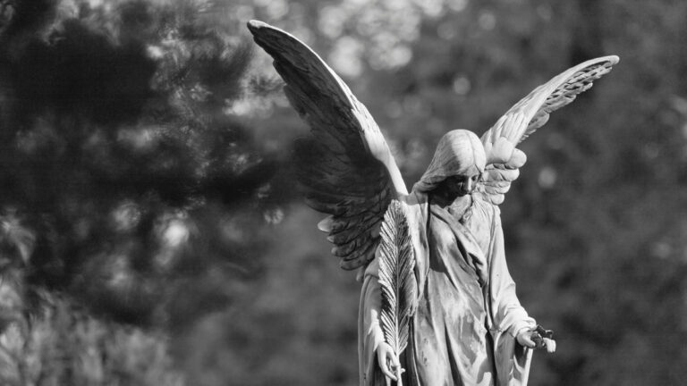 A statue of a sad angel in black and white