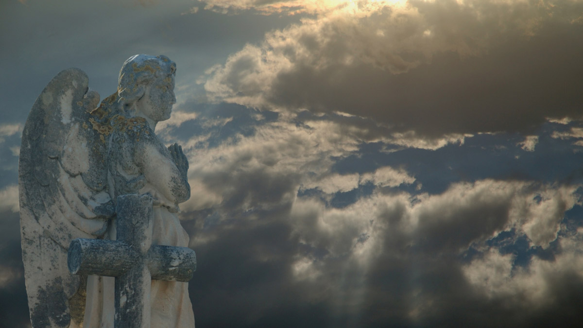 A statue of an angel hovering in the sky.