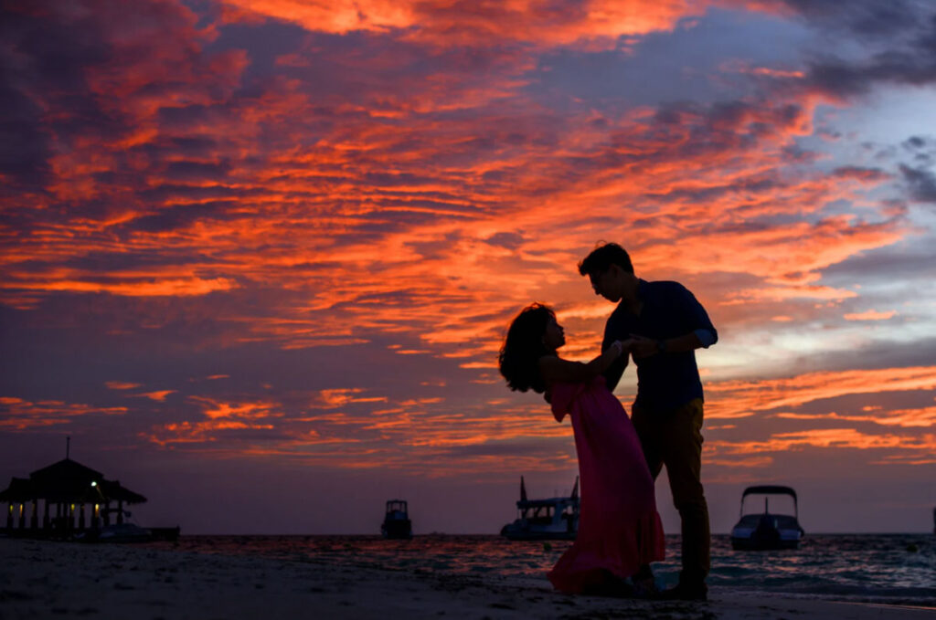 A silhouette of a couple dancing during sunset.