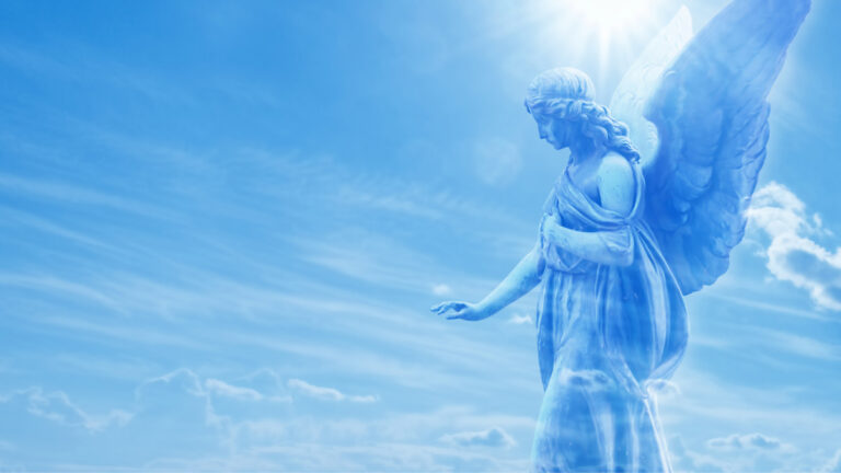 Statue of an angel overlooking a blue sky.