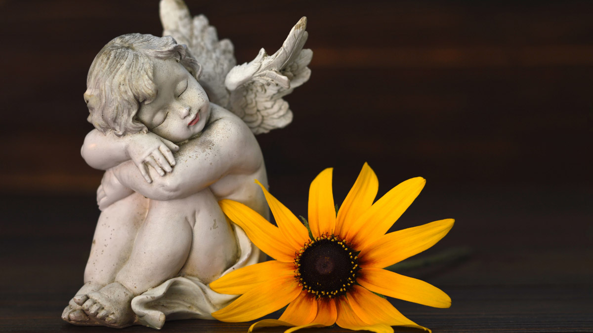 A child angel statue hugging themselves.