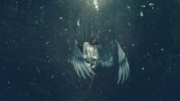 A woman with angel wings in a forest.