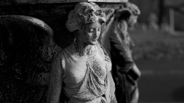 A worn out statue of an angel with wings.