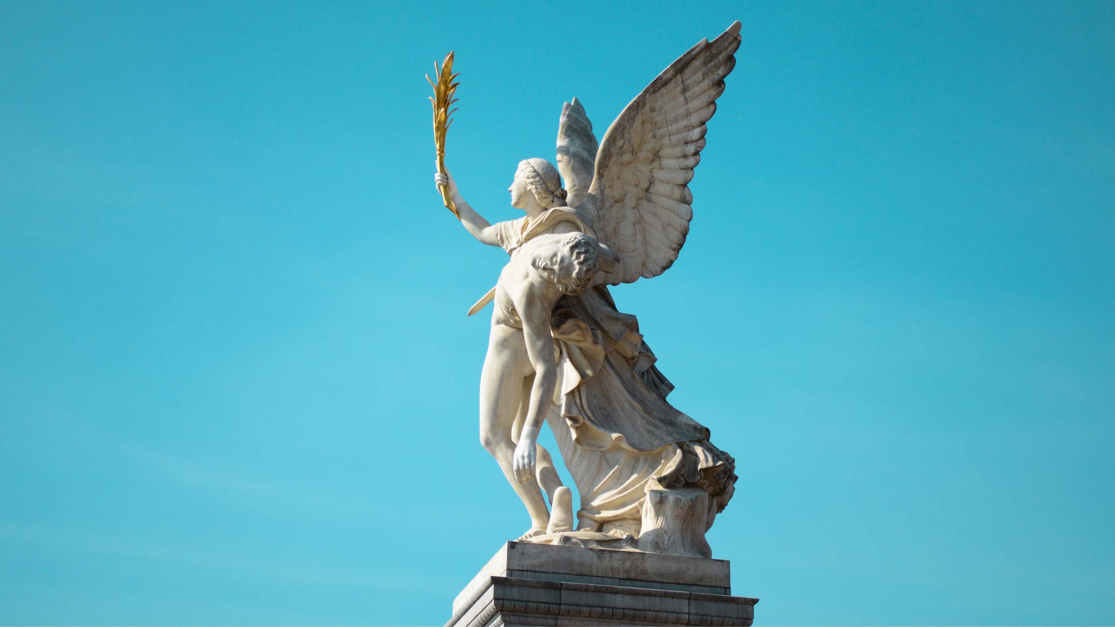 A winged angel statue in the sky with a blue background.