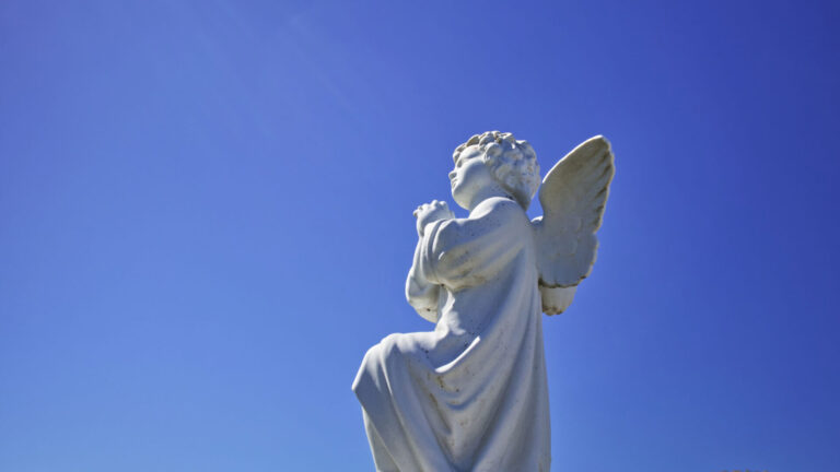 An angel statue in a blue sky.