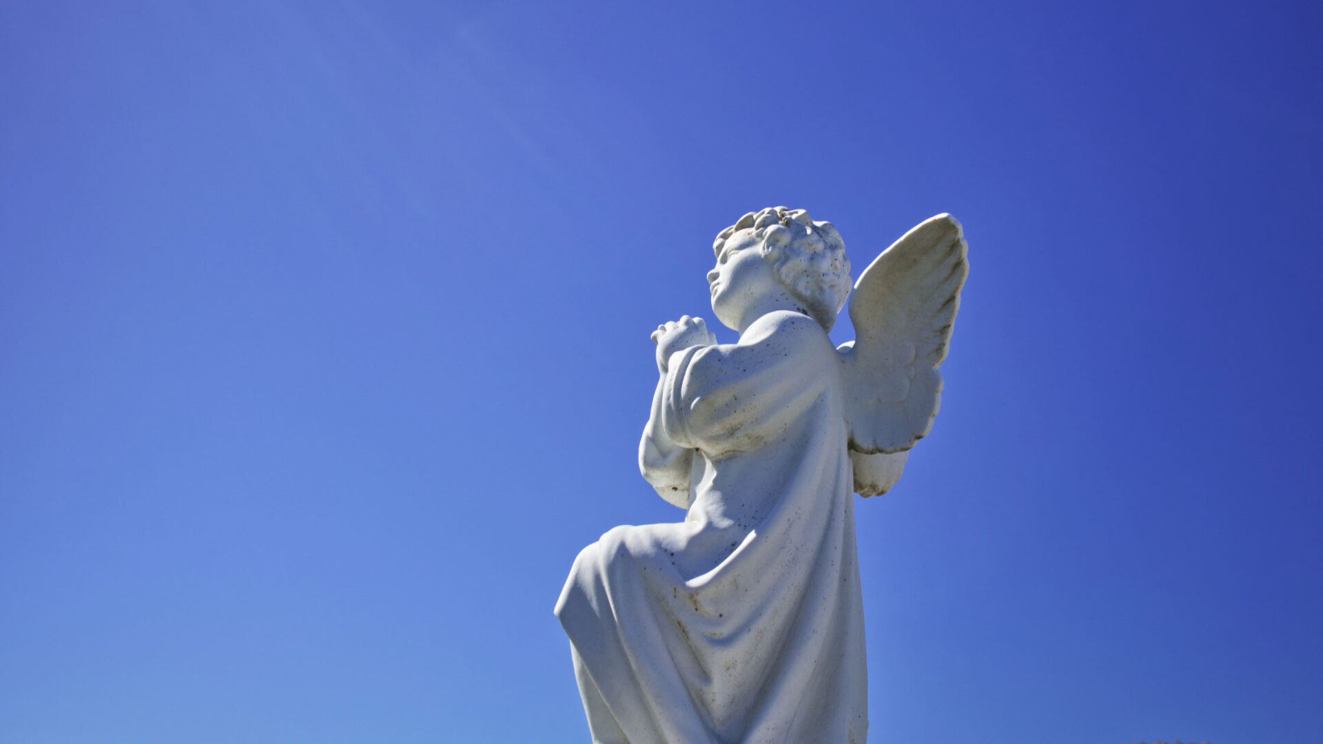 An angel statue in a blue sky.