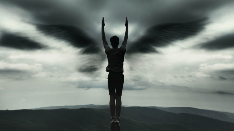 A man raising his arms in the shape of angel wings.